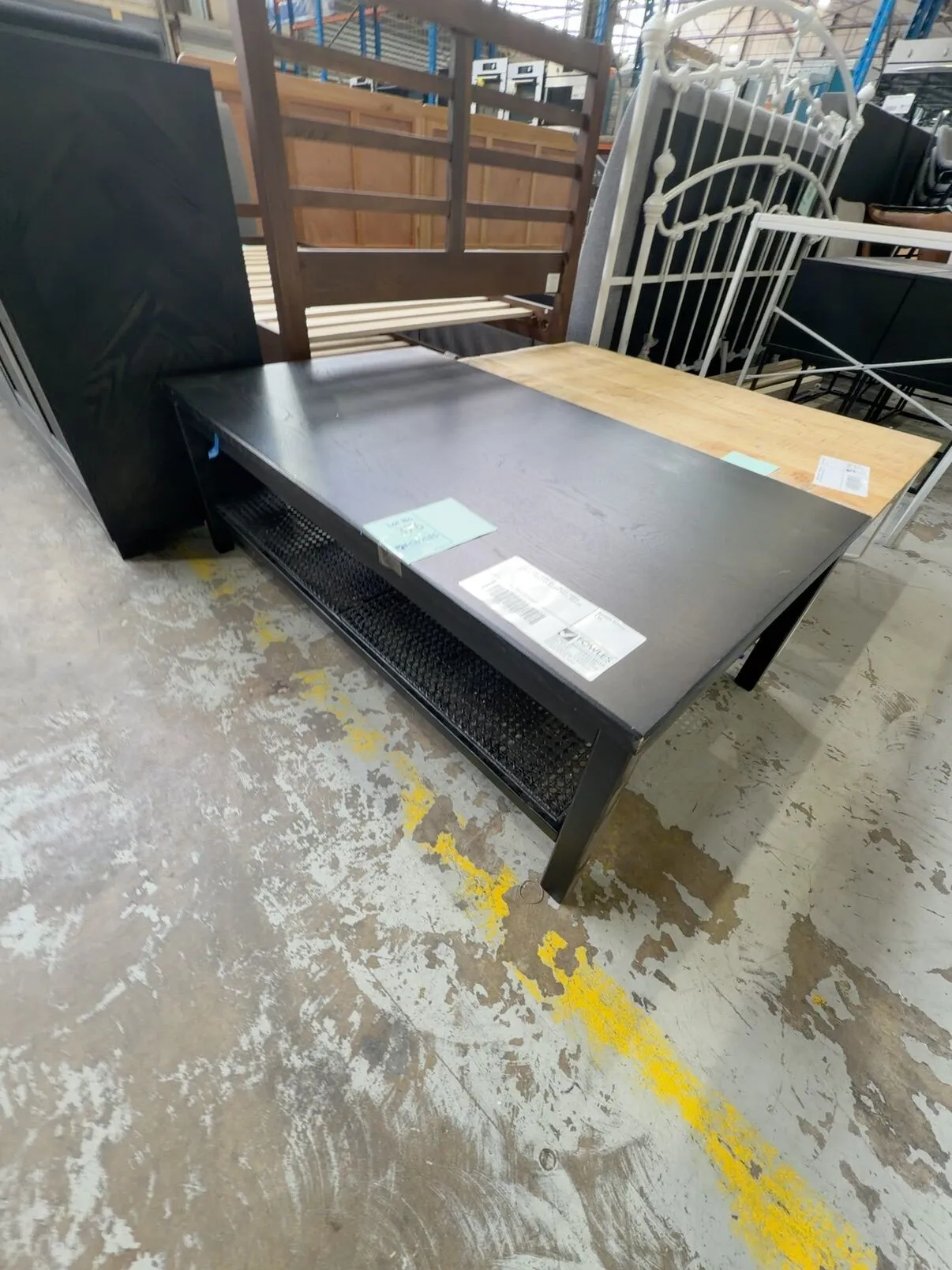 EX STAGING FURNITURE - BLACK TIMBER COFFEE TABLE WITH RATTAN SHELF, SOLD AS IS EX STAGING FURNITURE - BLACK TIMBER COFFEE TABLE WITH RATTAN SHELF, SOLD AS IS