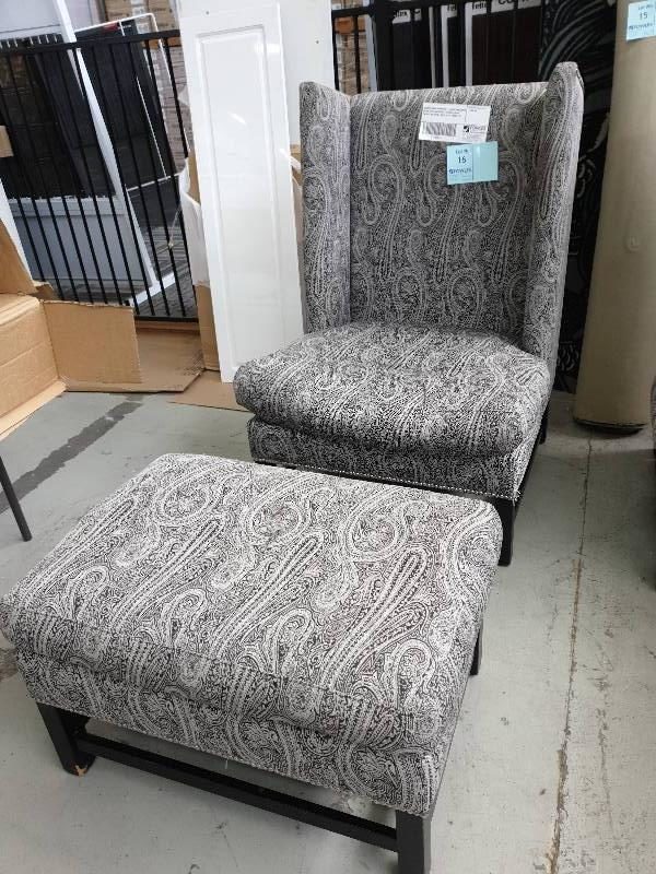 SECOND HAND FURNITURE - LARGE WINGBACK CHAIR WITH FOOTSTOOL SILVER & BLACK PAISLEY MATERIAL SOLD AS IS FADED ETC