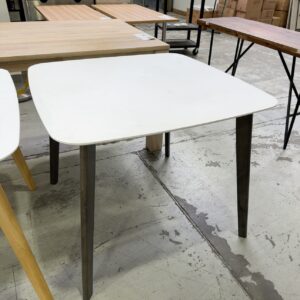EX STAGING FURNITURE - WHITE LAMINATE SQUARE DINING TABLE WITH TIMBER LEGS, SOLD AS IS