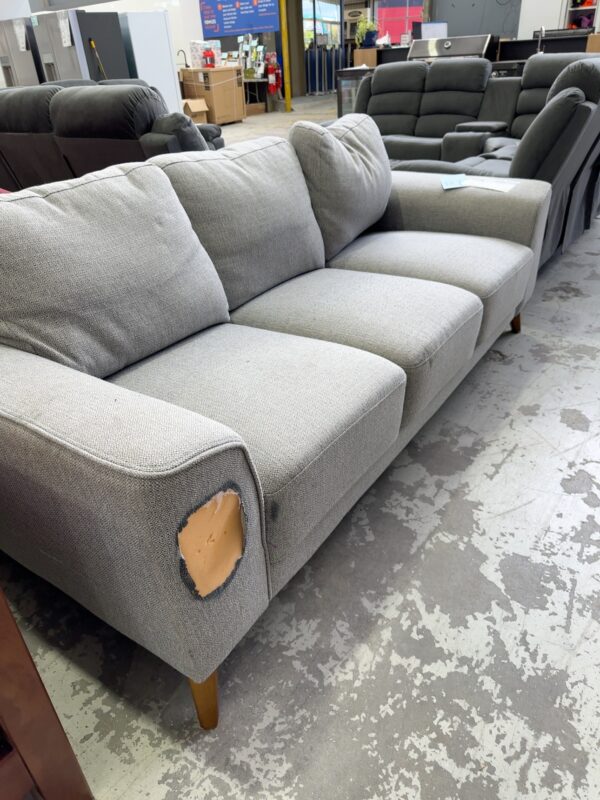 EX HIRE GREY & WHITE COUCH, RIP IN ARM ON FRONT LEFT, SOLD AS IS