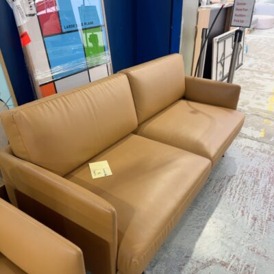 EX STAGING HIRE - TAN VINYL MID CENTURY STYLE 2 SEATER COUCH, SOLD AS IS **SOME SMALL MARKS, RUBS, SCRATCHES**