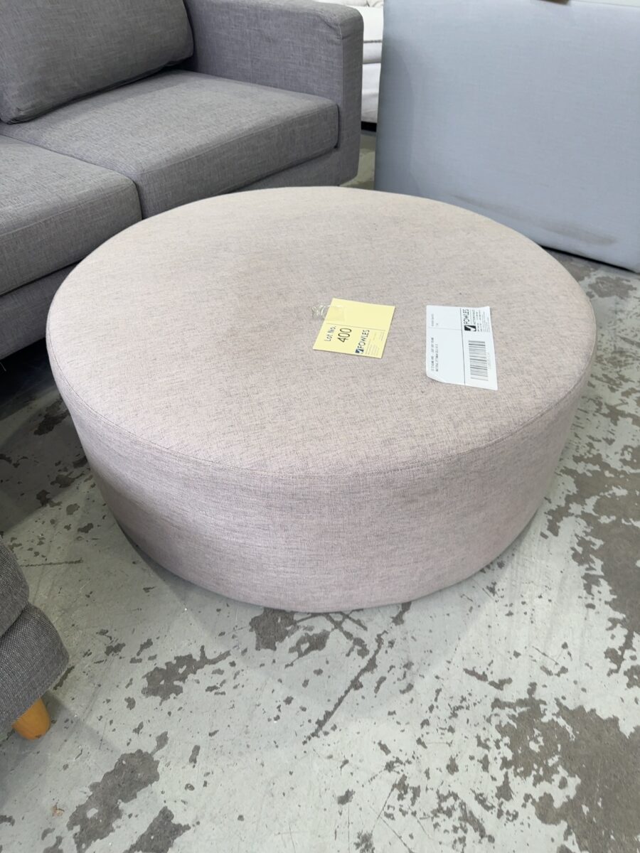 EX STAGING HIRE - LIGHT GREY ROUND MATERIAL OTTOMAN SOLD AS IS
