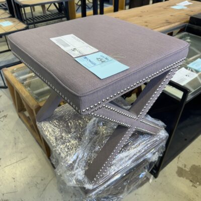 EX STAGING - GREY CROSS LEG OTTOMAN WITH STUD DETAIL, SOLD AS IS