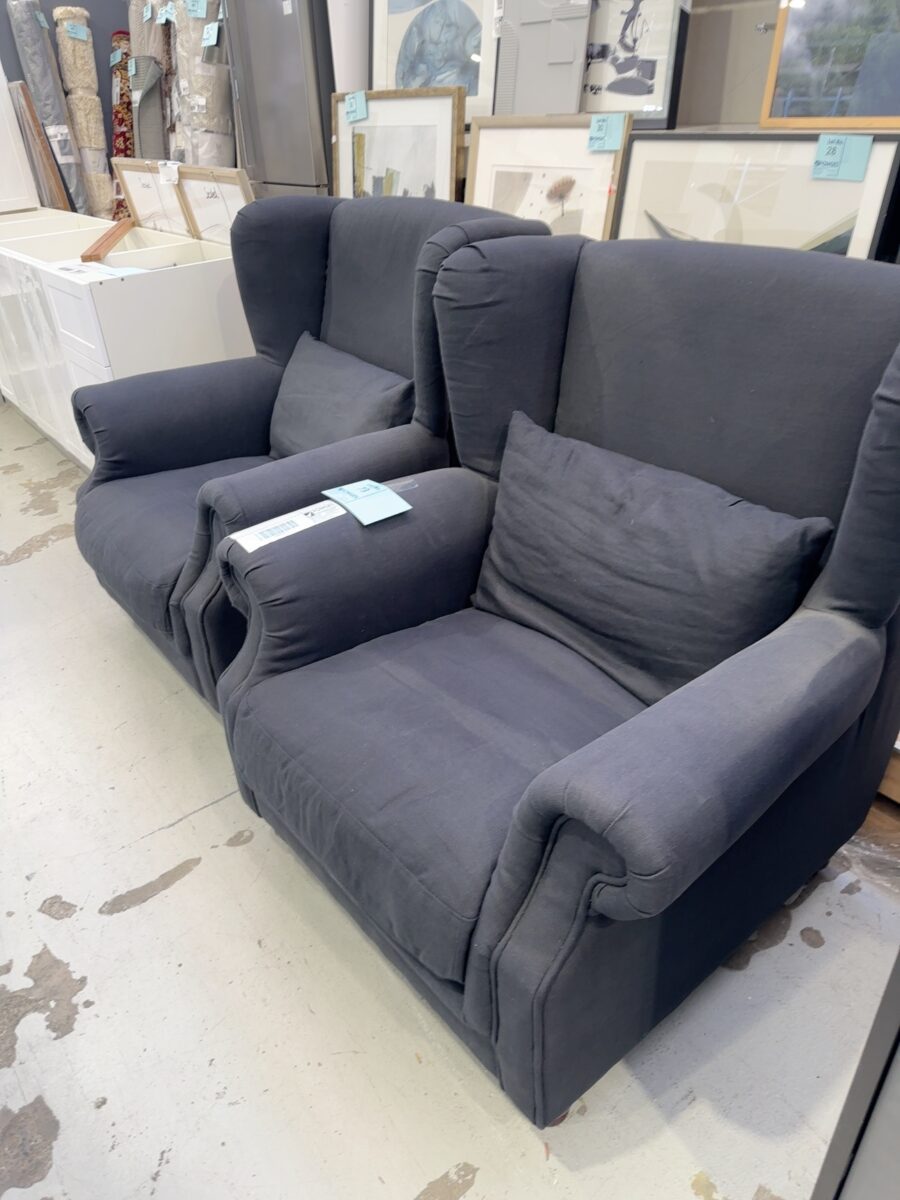 EX STAGING - LARGE BLACK MATERIAL WING BACK CHAIR, TIMBER LEGS, SOLD AS IS