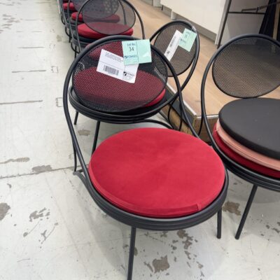 EX HIRE - ROUND BACK BLACK METAL FRAMED LOW CHAIR, WITH 3 CUSHIONS, ONE RED, ONE BLACK & ONE PINK, SOLD AS IS